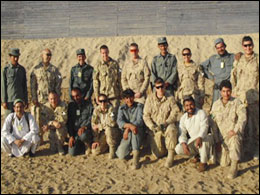 After a successful day of training, members of a Canadian Police Operational Mentor and Liaison Team line up for a photo with their Afghan National Police (ANP) crew. Canadian police and Canadian Forces are working together to train and mentor the ANP to increase their ability to promote law and order.