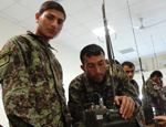 Soldiers in training at the ANA Signals School work with an AN/PRC 77 field radio.