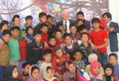 Glenn Davidson, Canada’s Ambassador to Afghanistan stands amongst children from the educational children's circus in Kabul.