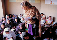 A teacher stands in a class of girls in a community-managed school