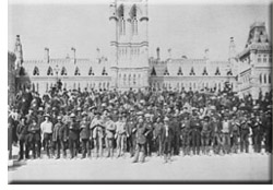 Ottawa Voyageurs standing before the Center Block of the Parliament Buildings.
