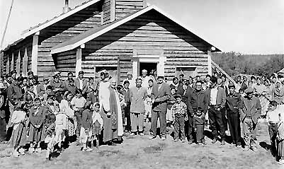 old picture with many Vuntut Gwitch'in people in 


front of  a church after a church service