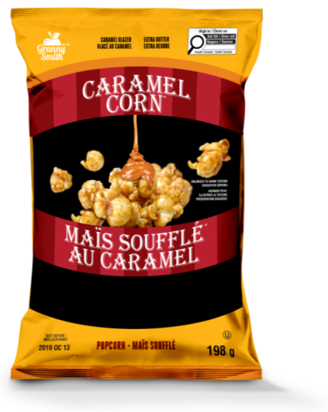 This is an image of the front panel of a bag of popcorn called Caramel Corn. In the top right corner is the magnifying glass nutrition symbol with the Health Canada attribution indicating that the product is high in saturated fat and sugars. 