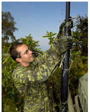 Soldier raising a Vixam radio communications mast at the front of a radio rebroadcast station truck in Haiti, 2010.