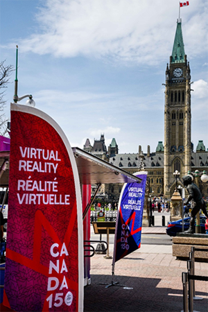 A set of feather flags are located at both ends of the virtual reality kiosk. The Peace Tower is in the background.