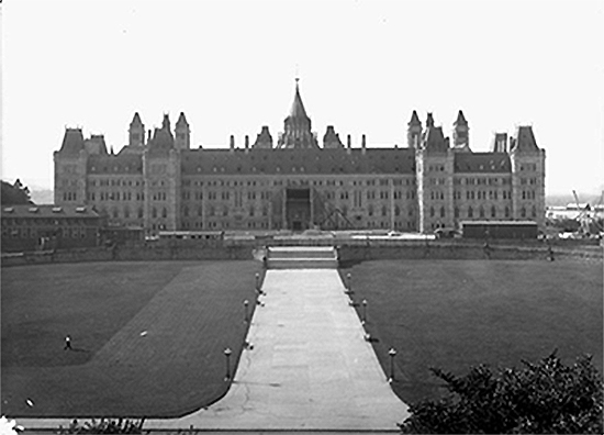 A historical black and white photo of the Centre Block building without its famous Peace Tower.