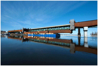 Une vue panoramique du pont des Allumettes où l’on peut voir la section centrale en acier être soulevée pour son installation