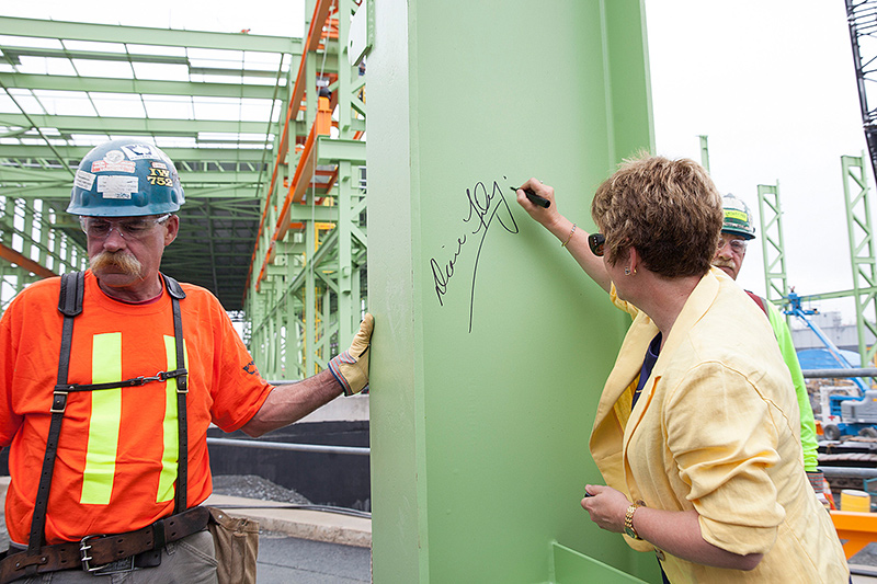 A woman signing a beam.