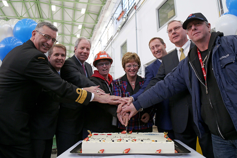 A group of women and men cutting a cake.