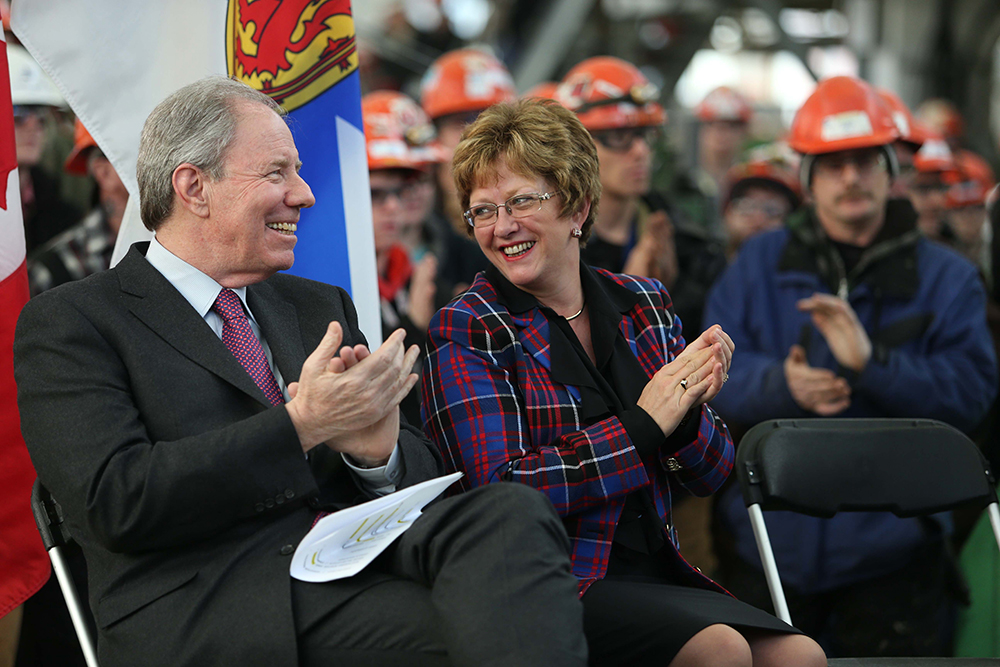 A woman and man smiling and clapping.