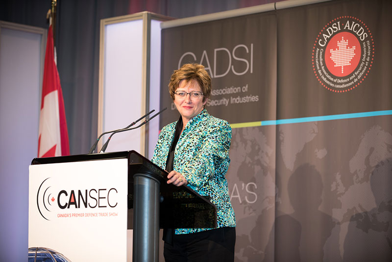 A woman standing behind a podium.