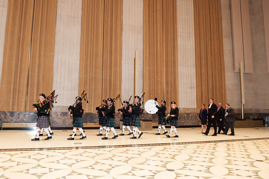 A pipe band, men and women walking.