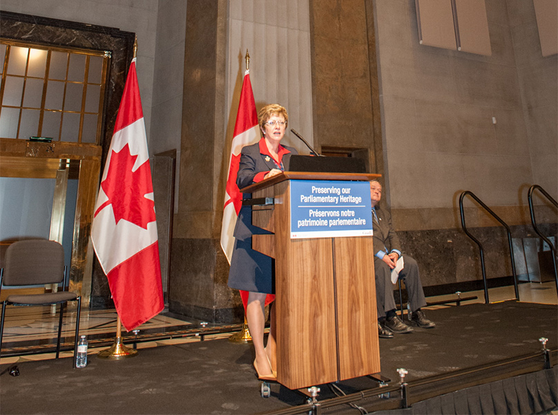 Woman standing behind a podium.