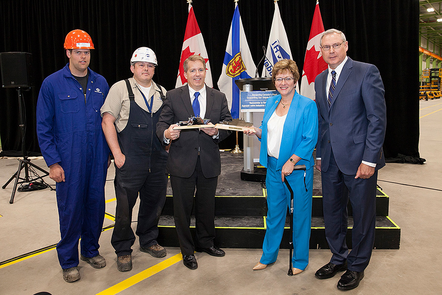 A group of men and a woman posing for a photo.