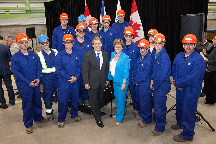 A group of men and a woman posing for a photo.