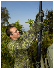 Soldat installant un mât de communication radio Vixam à l'avant d'un camion-station de rediffusion radio en Haïti, 2010.