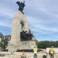 Six travailleurs s'exécutent sur les marches en béton d'un monument.