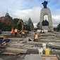 Construction workers placing paving stones.