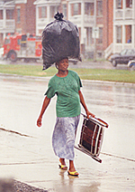 Photo: Woman walking down King Edward Avenue carrying her burden on her head, 1992.