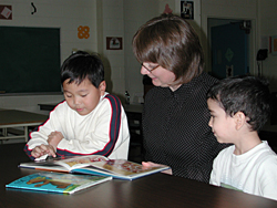 Linda Sigouin reads to two young students at Centennial Public School.