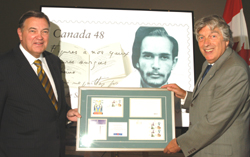 André Ouellet, President and Chief Executive Officer of Canada Post (left), presenting National Librarian Roch Carrier with a framed set of stamp materials