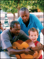 Two senior men and a child, with a guitar