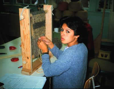 Krista Point weaving on a small table-top loom, photo 1996.  Photo Courtesy Krista Point.