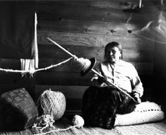 Selisya, a Musqueam weaver, spinning with a traditional Salish spindle, Photo by C.F. Newcombe, courtesy of Royal British Columbia Museum #PN1165, photo 1915.