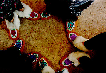 picture of five pairs of beaded moccasins with various different fur trim