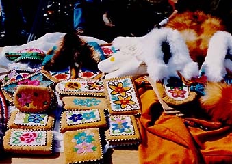 picture of several moccasins, beaded skin wallets, and other handmade crafts