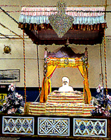 Sikh sitting on bed of pillows at the front of the temple
