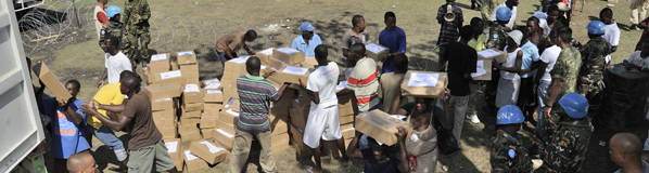 Des membres des Forces canadiennes assistent des soldats sri-lankais à distribuer de l'aide humanitaire aux Haïtiens à Léogâne.  Photo : Caporal Pierre Thériault 