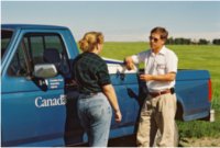 image - Two colleagues standing by a Canadian Food Inspection Agency truck and talking
