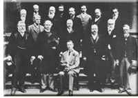 M. Joseph Chamberlain est centre posé. Se tenir sur son droite est M. Wilfrid Laurier.
