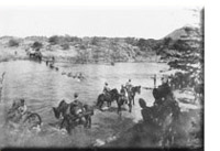 La force canadienne traverse à cheval le fleuve de Modder en Afrique du Sud.